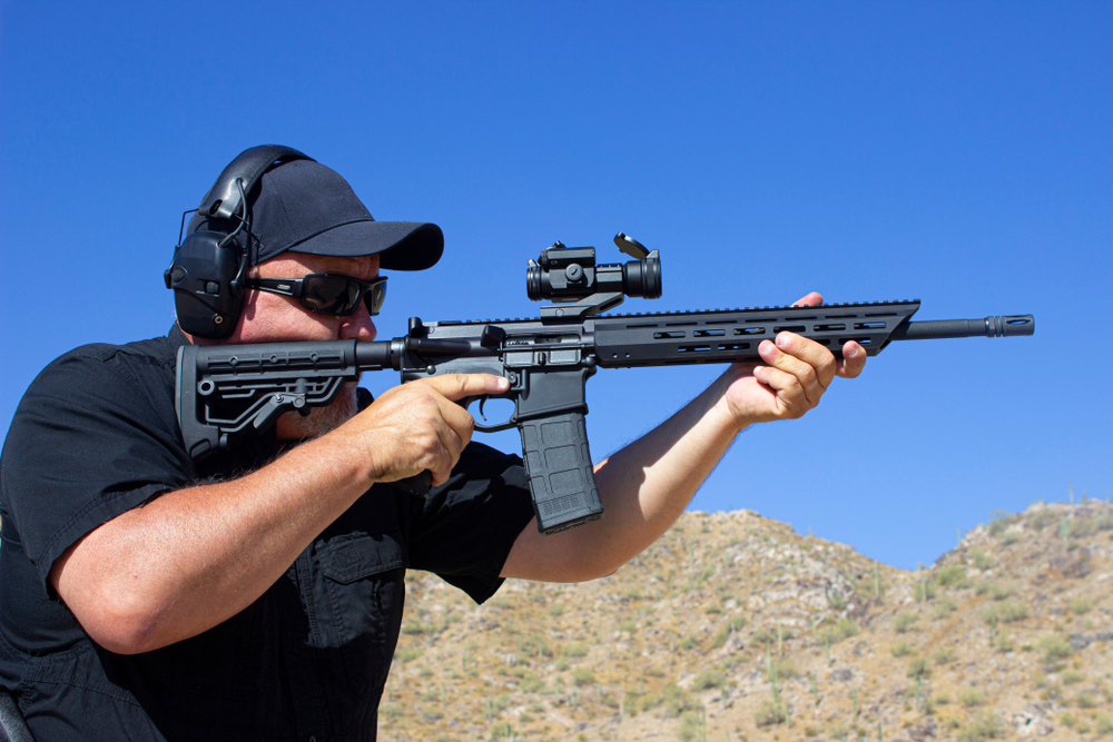 Man firing ar-15 style rifle at range