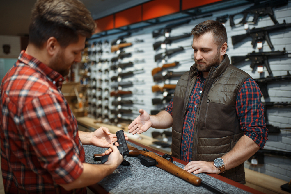 Consumer looking at handguns in shop
