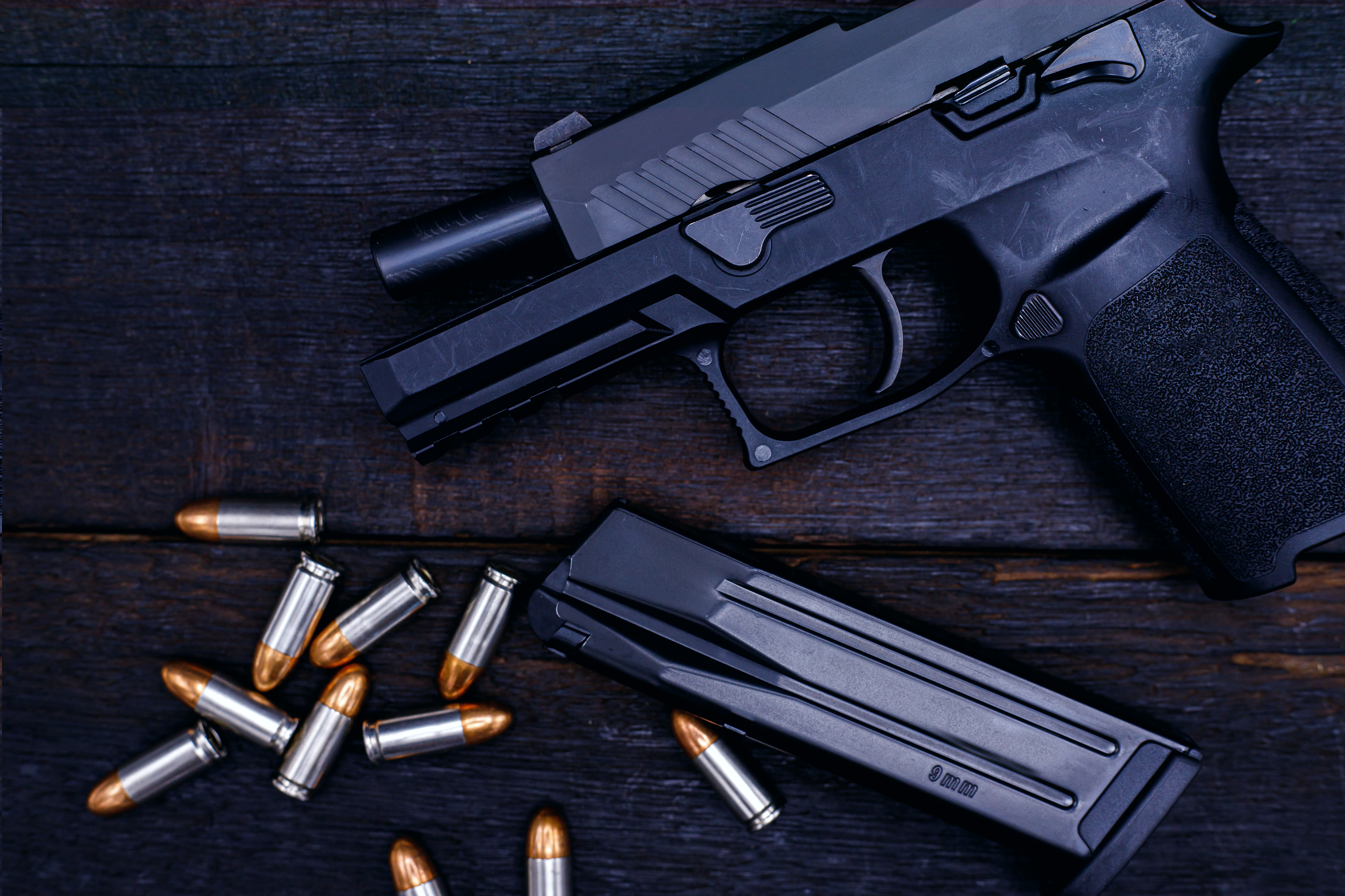 Sig Pistol on Table with Ammo laying beside it